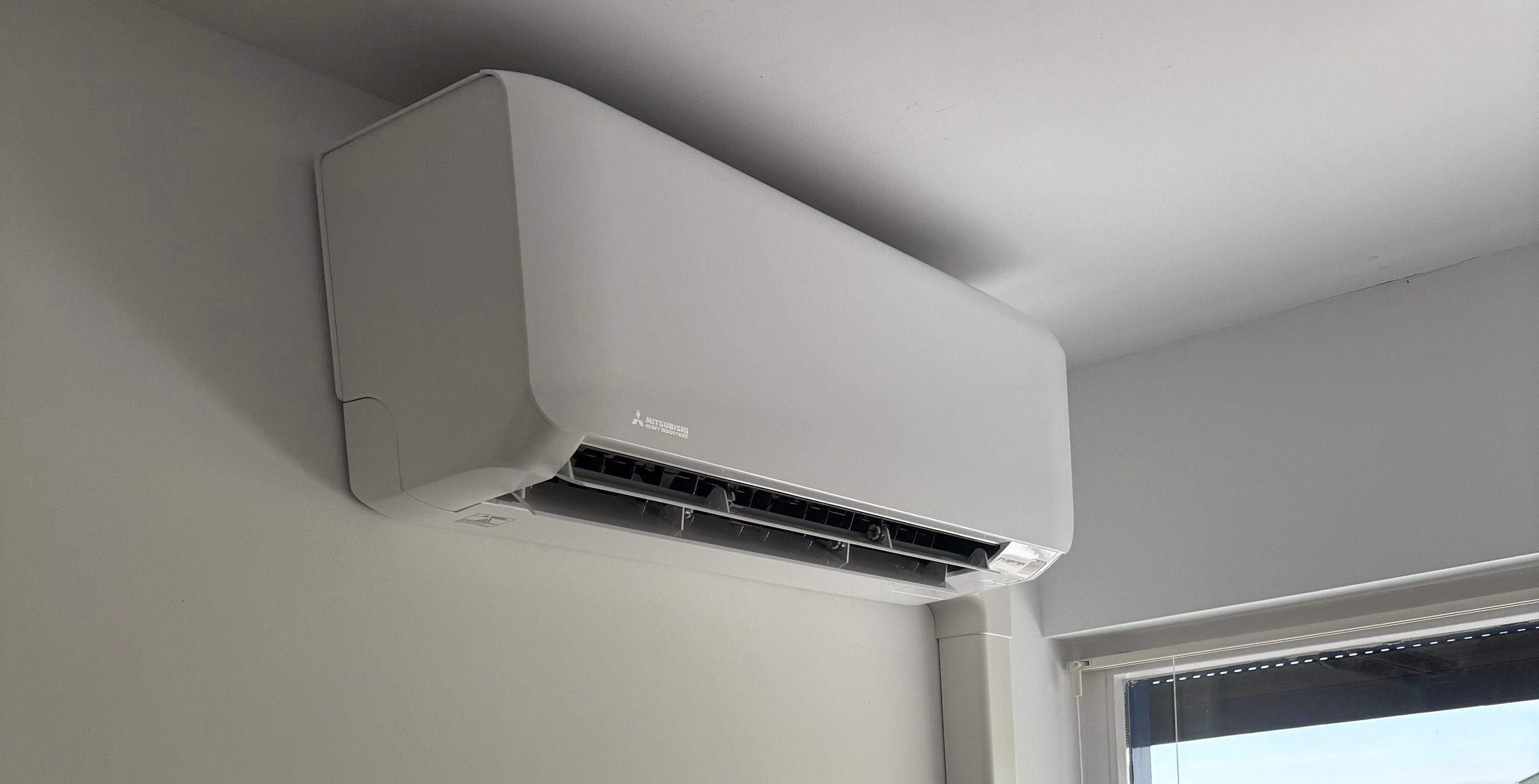 White air conditioning unit mounted near window
